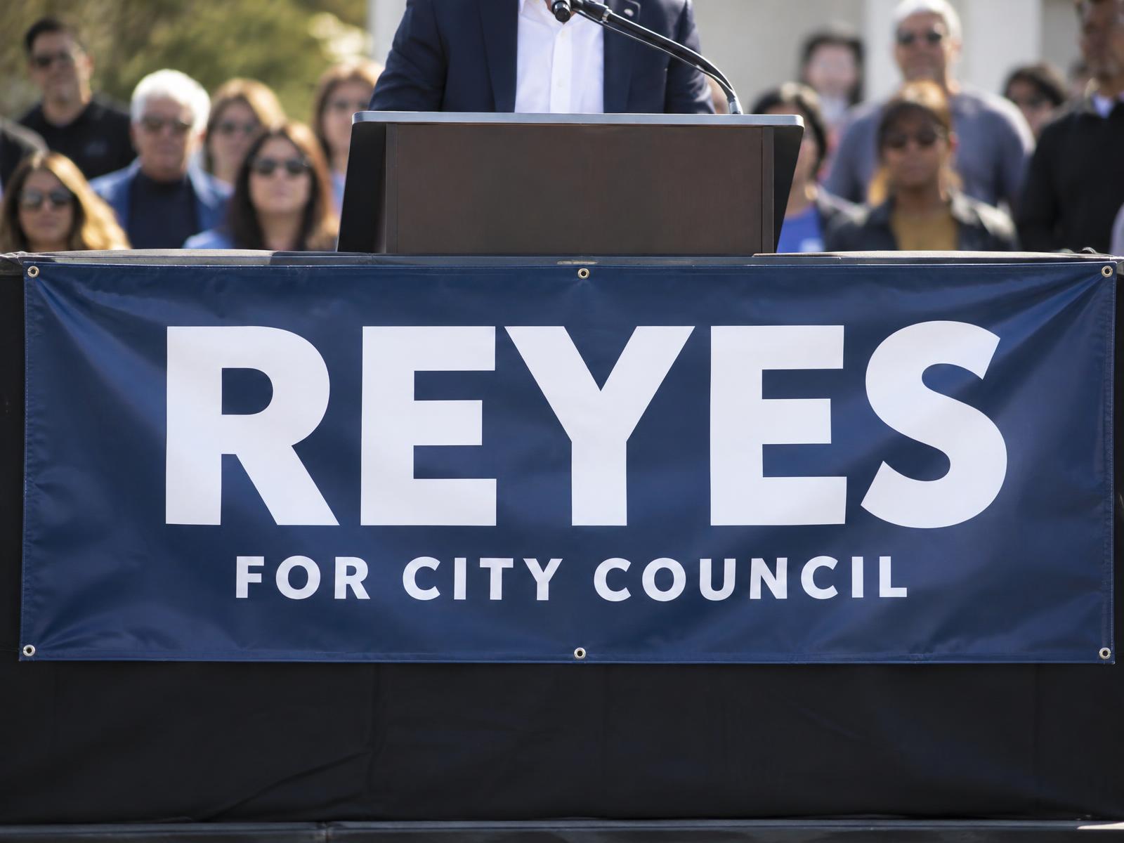 3 x 8 ft navy campaign banner reading Reyes for City Council on the front of a podium at an outdoor rally